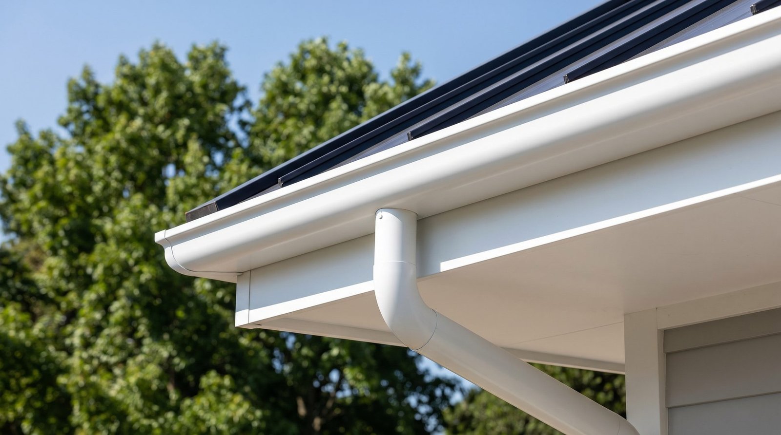 Newly installed seamless aluminum gutters and downspout on a home eave